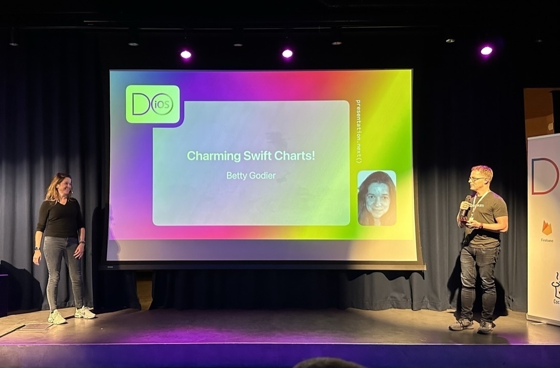 Picture of the stage of Do iOS 2022 with the intro slide for Betty visible. Betty to the left of the screen, Jeroen to the right.